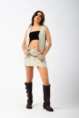 Minifalda de cuero color crema con cierre frontal con cremallera y bolsillos tipo cargo con botón a presión.