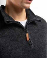 Sweater verde de punto con cuello alto y cierre medio con cremallera.