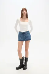 Falda mini de jean color azul, con pinzas en la parte delantera y cintura baja.