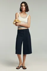 Camiseta sin mangas color amarillo pálido, de corte ajustado y cuello redondo.