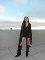 Minivestido negro de terciopelo con breteles finos y lazos colgando.