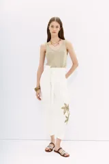 Pantalón blanco de tiro alto con corte paper bag, cintura con lazo a tono y bordado de lentejuelas y piedras en el lateral.