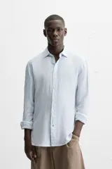 Camisa celeste de lino, de corte recto, manga larga y cuello clásico.