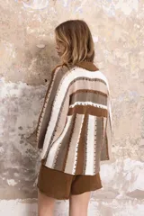 Saco tejido a rayas marrones, beige y blanco, con escote en V, mangas anchas y cierre frontal con botones.
