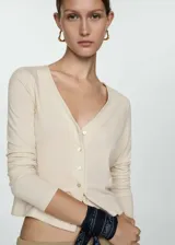 Cárdigan color crema de lyocell con cuello en V, cierre frontal con botones y mangas largas.