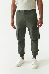 Pantalón cargo gris con puños elásticos, corte regular, bolsillos laterales con solapa y pasacintos.