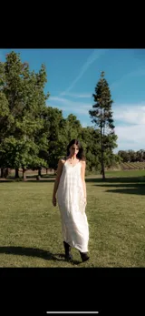 Vestido largo color crema con estampado geométrico lineal en negro, escote en V, breteles finos ajustables y bolsillos laterales.