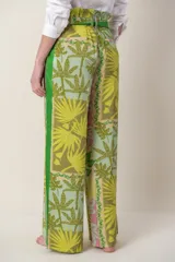 Pantalón ancho de tela blanca con estampado de flores azules, cintura alta con cordón ajustable y bolsillos laterales.