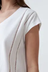 Remera color durazno con escote en V y detalle de vainillas en los laterales. De manga corta y corte recto.