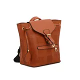 Mochila color beige con estampado a cuadros y detalles en marrón. Tiene una solapa con cierre de hebilla, un bolsillo frontal con cierre y un dije colgante con forma de cara sonriente.