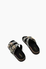 Sandalias planas con estampado de cebra, suela de corcho y hebillas doradas.