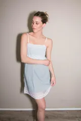 Camisón corto gris con puntilla blanca en escote y ruedo, de breteles finos.