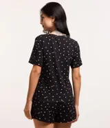 Conjunto de pijama negro con estampado de lunares, caritas sonrientes y la palabra "love". Incluye una blusa de mangas cortas y un short con cintura elastizada.