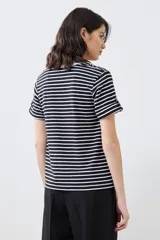 Remera de algodón a rayas horizontales blancas y negras, con cuello redondo blanco y mangas cortas con dobladillo.