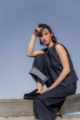 Zuecos de gamuza color marrón chocolate, con base de goma negra, tachas plateadas alrededor de la base y plantilla acolchada.