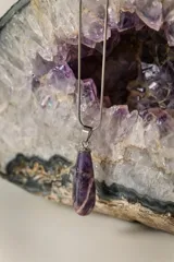 Collar dorado con cadena fina y dije colgante en forma de lágrima de piedra natural azul con vetas blancas.