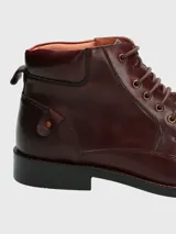 Bota de cuero color marrón con cordones, caña media y suela de goma.