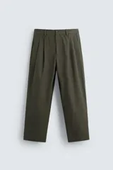 Pantalón verde oliva de corte amplio con pliegues en la parte delantera, bolsillos laterales y traseros de ojal.