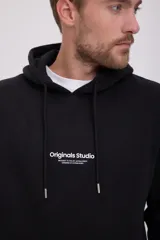 Canguro negro de manga larga con capucha, corte relajado y bolsillo tipo canguro. Estampado frontal con la inscripción "Originals Studio Brought to you by Jack&Jones Designed in Copenhagen".