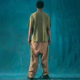 Remera verde militar de corte oversize con cuello redondo y estampado pequeño en el pecho con el logo de Kaboa Industries.