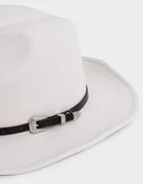 Sombrero fedora color crudo con cinta decorativa de cuero sintético negro y hebilla metálica plateada.