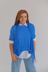 Sweater azul con escote redondo y detalle de encaje en el ruedo. Incluye chalina de gasa al tono con detalle de encaje.