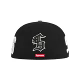 Gorra negra de la colaboración Supreme x New Era, modelo 59Fifty, con logo "S" en blanco en el frente, logo de Supreme bordado en el lateral y logo de New Era en el otro lateral.