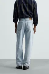 Pantalón de jean celeste de corte recto, con cinco bolsillos, efecto lavado y cierre frontal con botones.