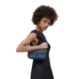 Bandolera de denim azul con estampado de margaritas, cierre magnético y correa de cuero extraíble. Se puede usar como bolso de mano o al hombro.