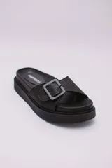 Sandalias negras de plataforma con hebilla ajustable y suela track.