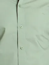 Camisa azul marino de manga larga con cuello abotonado y corte clásico.