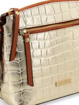 Cartera bandolera dorada con textura croco, correa de cuero marrón regulable y chapita metálica con logo de la marca.