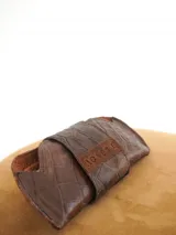 Estuche para lentes color borgoña con textura símil cocodrilo y cierre con broche a presión.