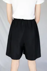 Bermuda holgada negra con cintura elastizada y hebillas de ajuste.