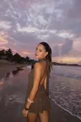 Vestido corto color marrón con brillos, escote halter y espalda descubierta.