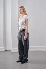 Top blanco de jersey de algodón con escote en V cruzado y mangas cortas. Se ata en la cintura con lazos laterales.