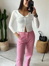 Remera negra de tejido de punto acanalado, con cuello polo, cierre frontal con botones y mangas largas.