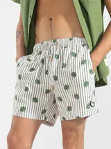 Short de baño celeste con rayas verticales blancas y estampado de flores blancas.