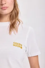 Remera blanca de algodón con cuello redondo y bordado dorado con la frase "Golden Hour".