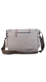 Morral de tela canvas color gris con detalles en cuero marrón. Tiene tapa con hebillas, doble bolsillo frontal, trasero y laterales. Interior espacioso con compartimento para notebook de 15". Correa de galón regulable.
