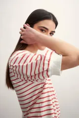Remera de manga corta con cuello redondo y estampado de rayas horizontales blancas y negras. Mangas abullonadas con puño blanco.