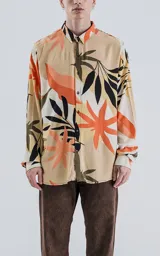 Camisa de manga larga con estampado de hojas en tonos beige, naranja, negro y verde.