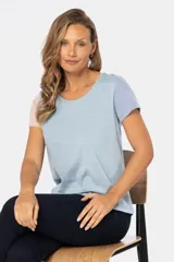 Remera de manga corta y cuello redondo, con bloque de color: cuerpo color crema, manga derecha color rosa y manga izquierda color celeste.