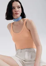 Musculosa slim color ocre, de tela acanalada con cuello redondo y sisas anchas.