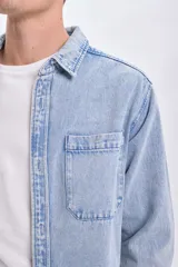 Sobrecamisa de jean celeste con dos bolsillos frontales con solapa y cierre abotonado.
