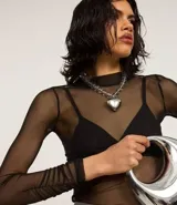 Blusa de tule transparente color negro, con cuello alto y mangas largas.