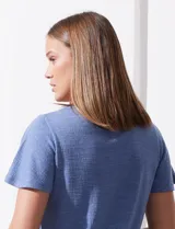 Remera color verde con escote en V y mangas cortas con volados. Presenta apliques de crochet en el escote y en el centro del frente.