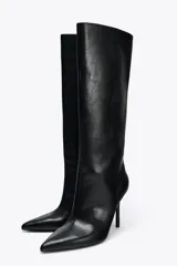 Bota negra de caña alta y corte recto, con puntera fina y tacón de aguja.