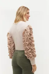 Remera negra de punto con mangas largas abullonadas con volantes.