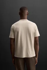 Camiseta relaxed fit color beige confeccionada en tejido con mezcla de algodón, cuello redondo, manga corta y logo estampado en el bajo. Zara Athleticz.